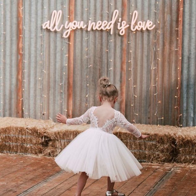 All You Need is Love neon sign with a pretty flower girl at a country wedding - from Custom Neon