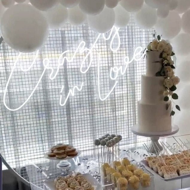 Crazy In Love Wedding Sign in brilliant LED neon flex shown in white with balloons and a wedding cake - photo from CustomNeon.com