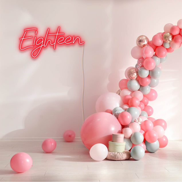 Eighteen Light Sign shown in red with a balloon arch and presents | Custom Neon®