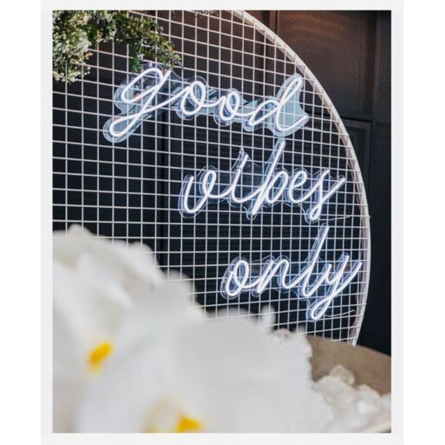 Good Vibes Only LED neon sign in 3 pieces shown on a mesh screen at an event - photo from CustomNeon.com