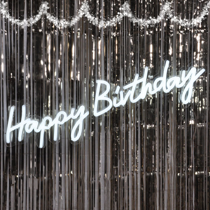 Light up "Happy Birthday" sign - shown against party decor. Photo from CustomNeon.com