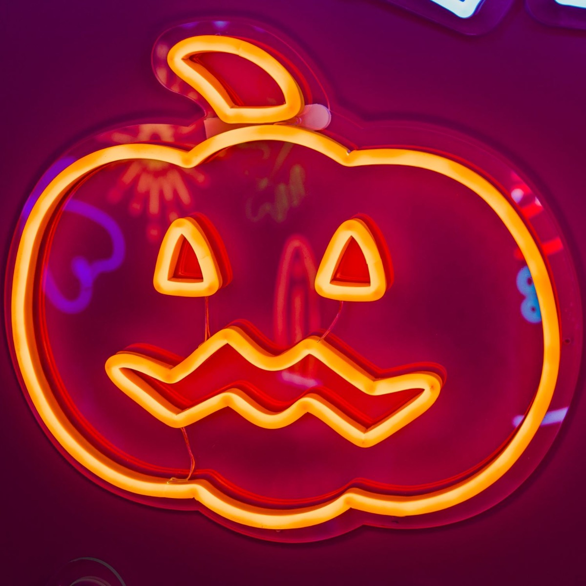 Spooky Light Up Jack O Lantern in pumpkin orange shown illuminated in a dark setting - CUSTOM NEON® Halloween Decorations