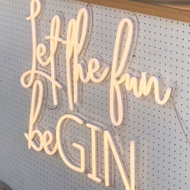 Let the Fun beGIN large neon sign - shown attached to the front of a gin bar at an event - photo from CustomNeon.com