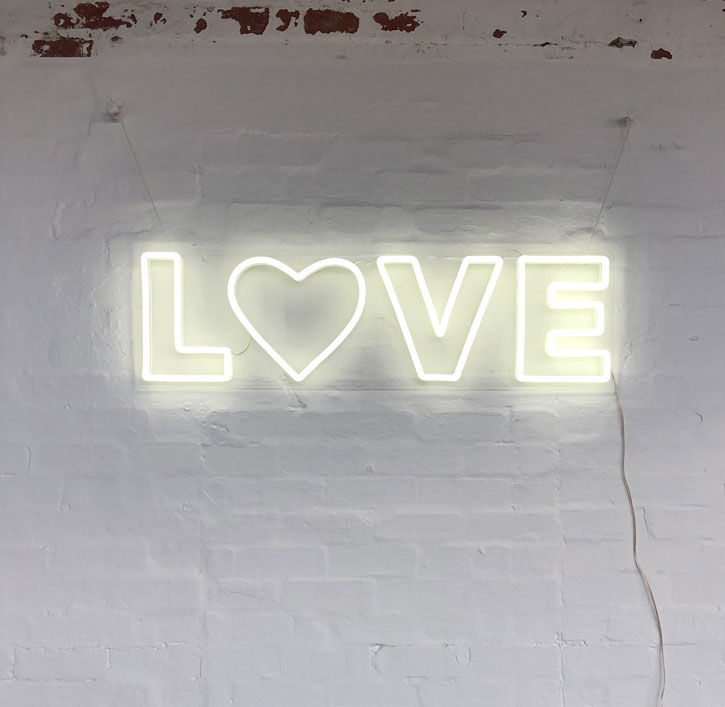 modern neon letter lights spelling the word LOVE with a heart for the O
- photo from CustomNeon.com