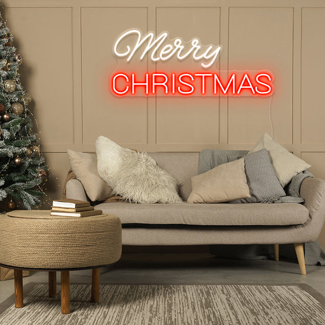 Merry Christmas LED Neon Sign shown wall mounted in a living room near a Christmas tree - by CUSTOM NEON®