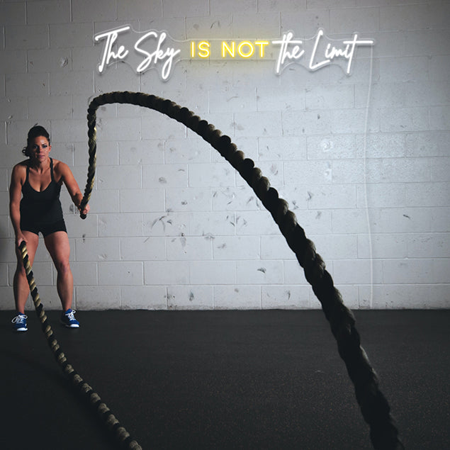 The Sky is Not The Limit CUSTOM NEON® sign shown in white & warm white on brick wall in fitness/boxing studio