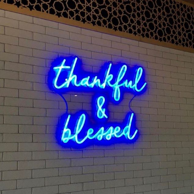 Thankful & Blessed blue neon sign shown illuminated on brick wall - made by @customneon for @9gramscafe