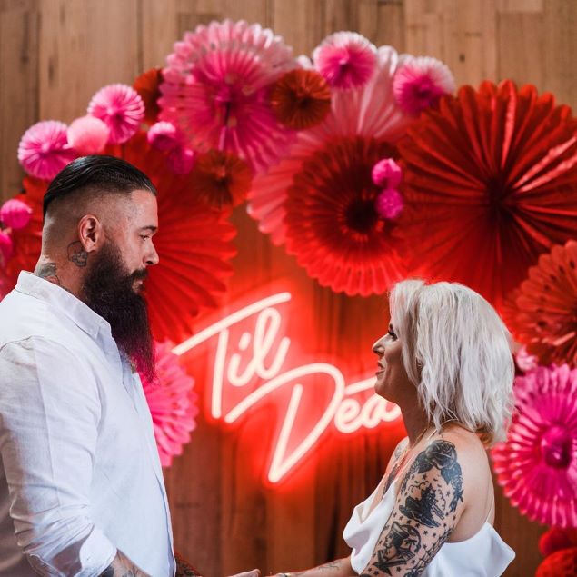 Til Death faux neon sign on the photo wall surrounded by wedding decorations - from Custom Neon