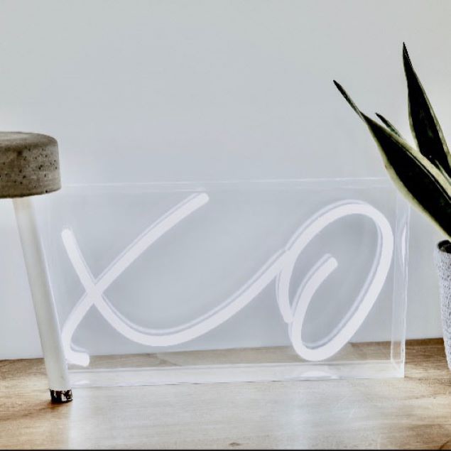XO tabletop LED neon sign in acrylic box shown on a table during an event - photo from CustomNeon.com