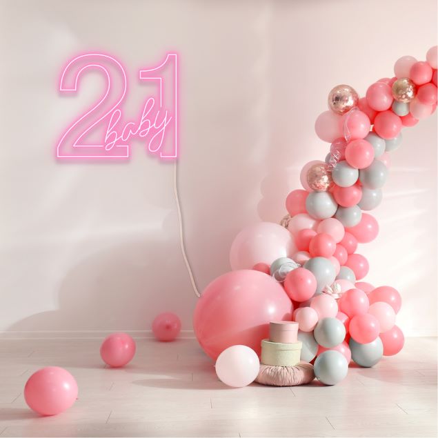 21 Baby Neon Sign shown in pink next to a balloon arch from CustomNeon.com