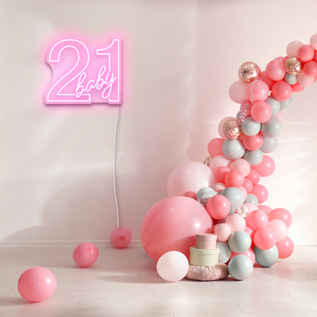 21 Baby Neon Sign shown in pink next to a balloon arch from Custom Neon
