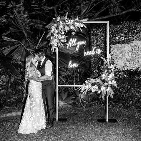 All you need is love faux neon sign in 3 pieces shown in black and white at a wedding - from Custom Neon®