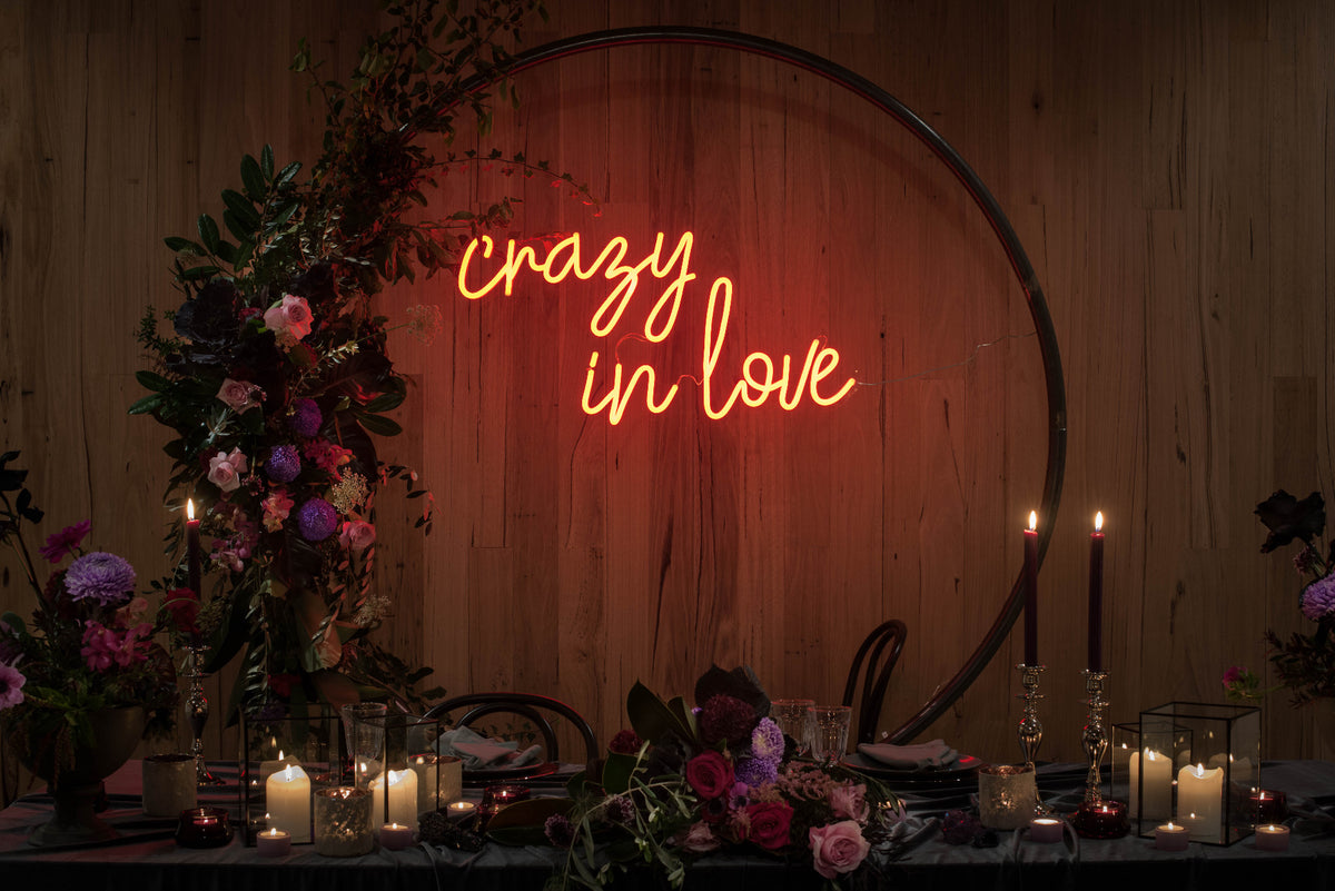 Crazy in Love Neon Wedding Sign behind the bride & groom's table - photo from CustomNeon.com