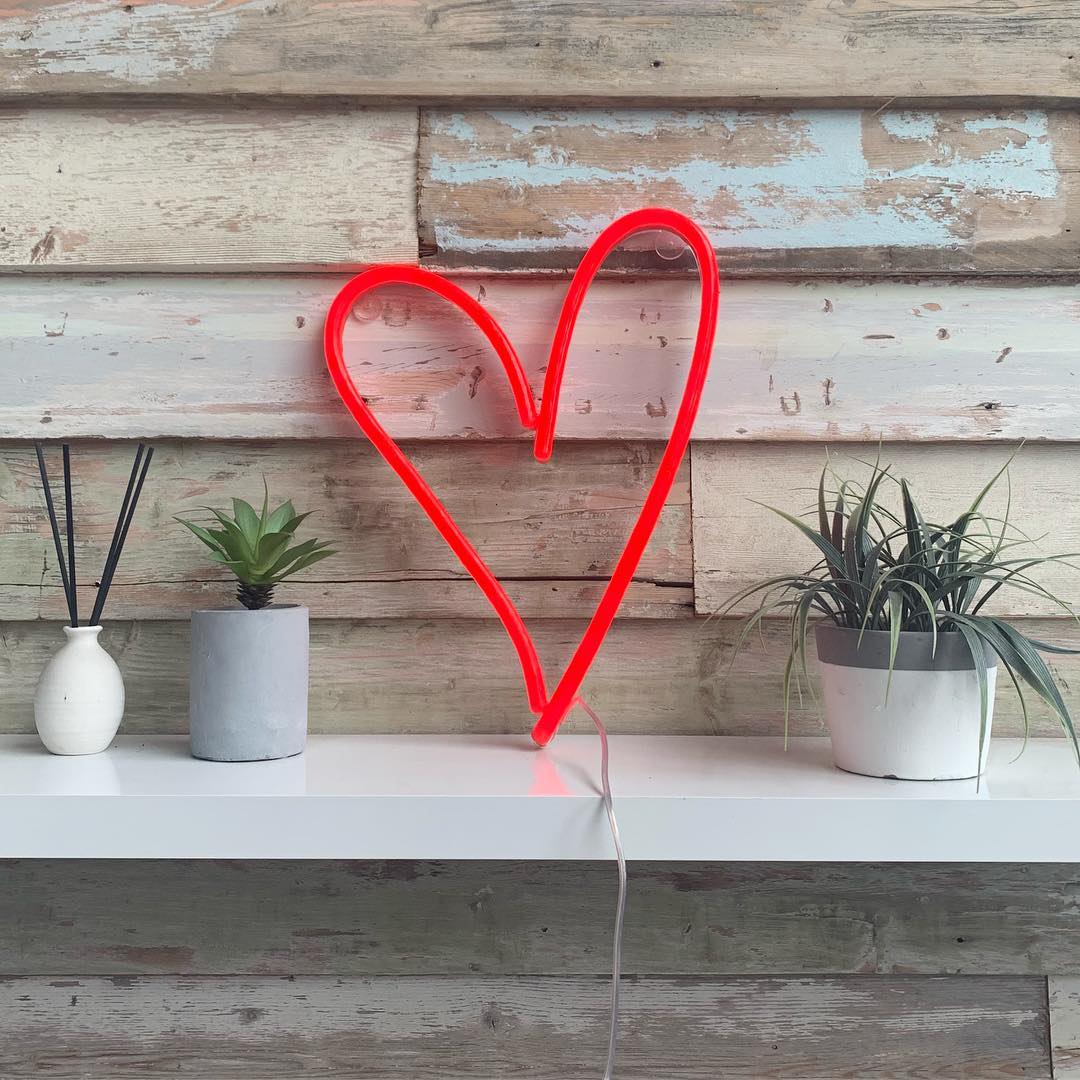 White love heart neon light wall mounted above roses at a special occasion - Custom Neon