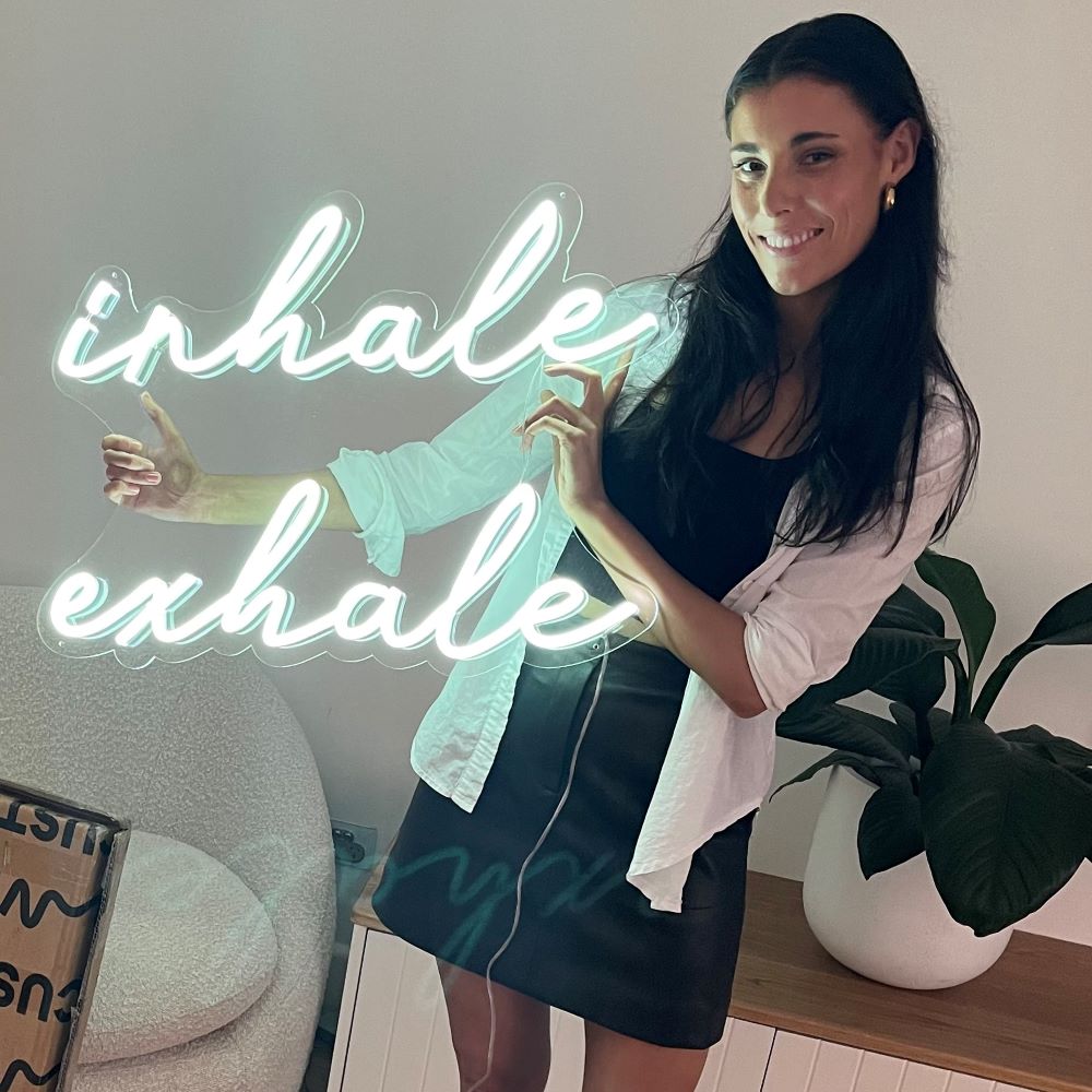 Inhale Exhale Custom Neon® wall sign shown illuminated on a white wall