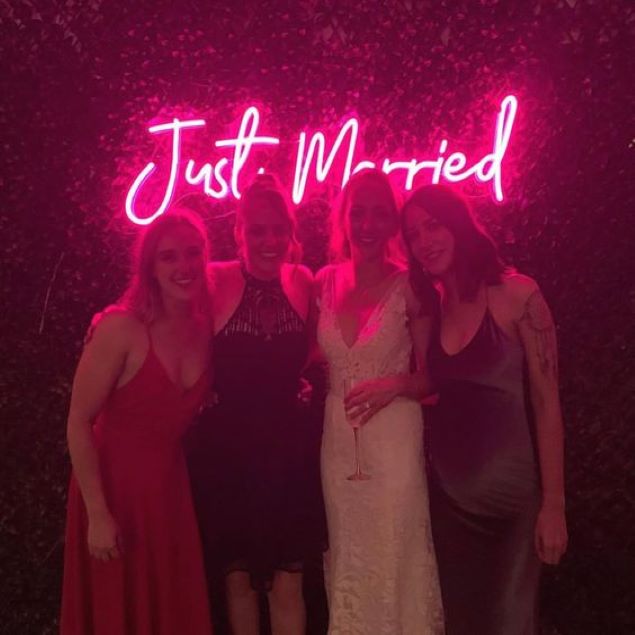 Just Married Light Up Sign hung from a wedding photo backdrop - from Custom Neon™