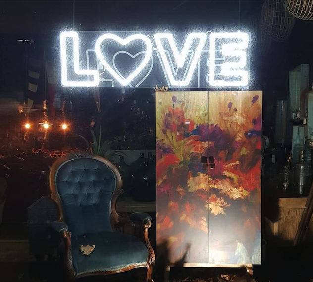 LOVE with a heart LED neon sign surrounded by wedding decorations - photo CustomNeon.com