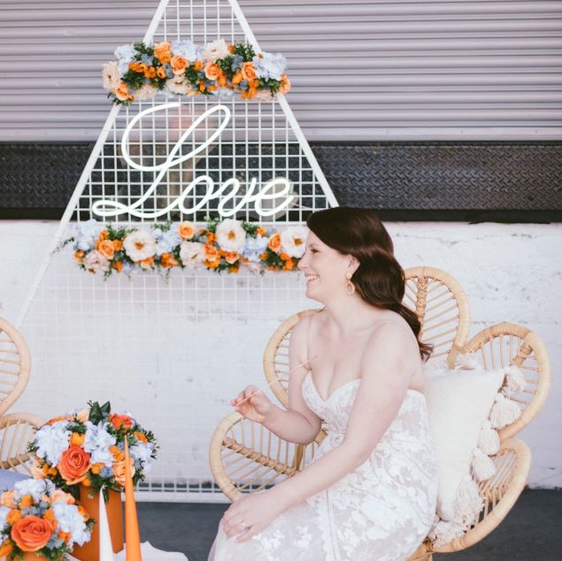 Romantic Love Sign in LED Neon Flex shown behind the bride at a wedding - from Custom Neon™
