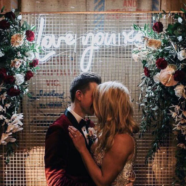 Love You XO LED Neon Light Sign for Weddings shown on green wall background - photo CustomNeon.com