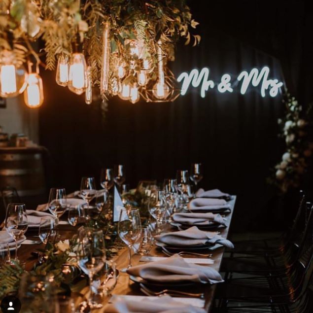 Mr & Mrs light sign behind he wedding cake - from Custom Neon