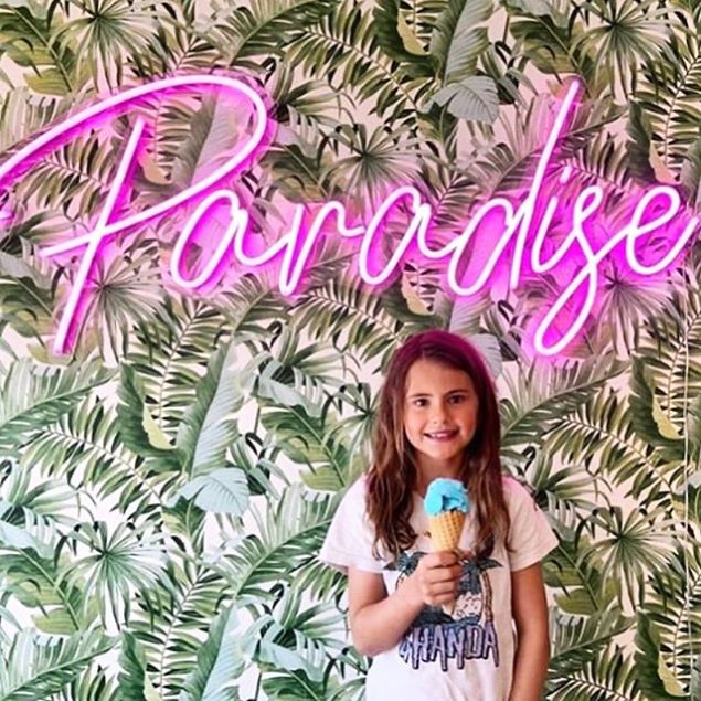 Paradise Neon Sign shown in pink at an ice cream parlor - from Custom Neon