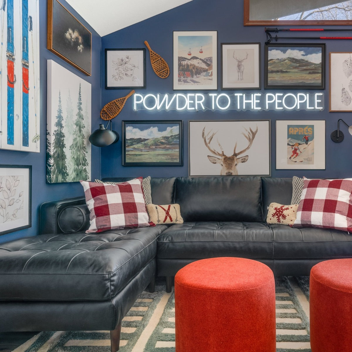 Powder to the People white LED neon sign on a blue feature wall surrounded by framed skiing related paintings and prints - CUSTOM NEON™ x SOMERLED COLLECTION