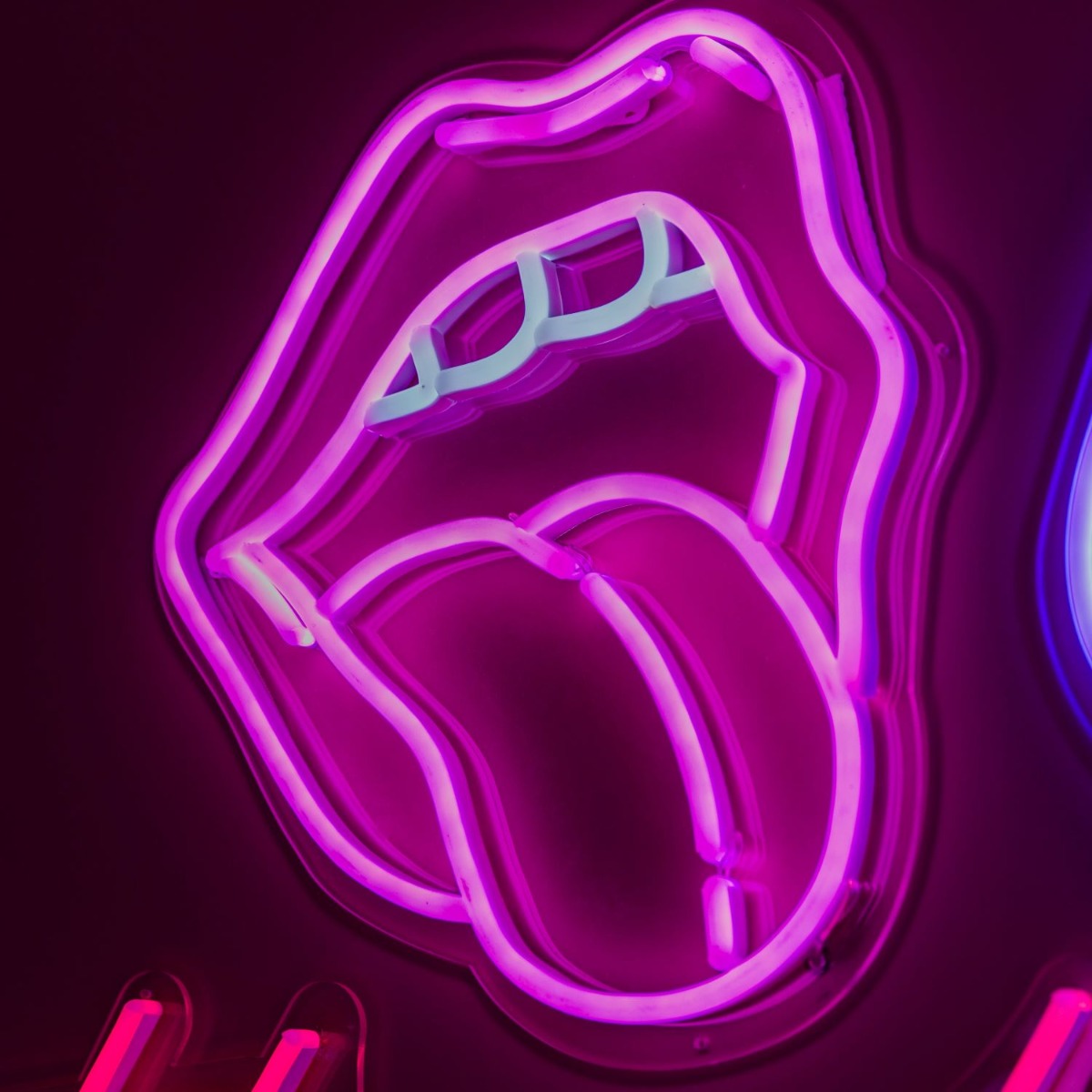Custom Neon® pink tongue shown illuminated against a dark background in dim light